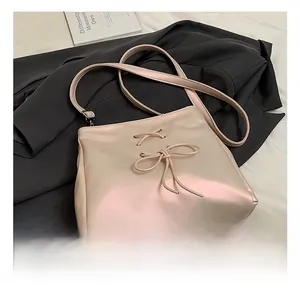 Detail of champagne pink ballet style bag featuring bow tie laces and soft PU leather