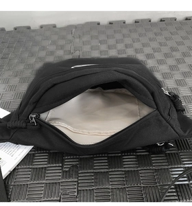 Vue détaillée de l'intérieur du sac en toile noire avec doublure crème et poche interne