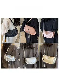 Detail view of crescent underarm bags with stylish tassels in four elegant color variants