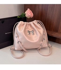 Detail of light pink drawstring backpack with metallic bow and adjustable silver buckle
