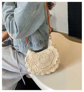 Detail of crochet beige crossbody bag with scallop trim and brown leather shoulder strap