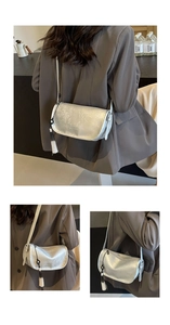 Detail of silver floral jacquard fabric and stylish tassel on the saddle bag shoulder strap