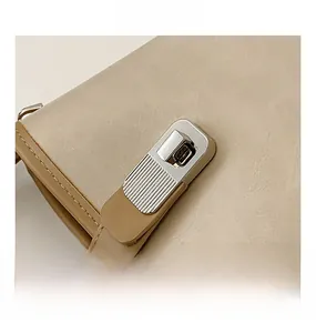 Detailed close-up of a silver rectangular metal twist lock on a beige bucket handbag