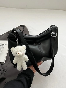 Black half-moon tote bag with bear charm and adjustable strap for women
