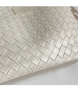 Detailed macro shot of high-quality woven faux leather texture and minimalist logo on tote bag