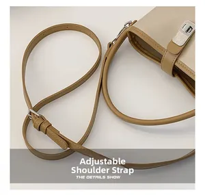 Detail view of adjustable beige leather shoulder strap with silver metal buckle on bag