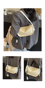 Detail of cream leather shoulder bag with long black and white gradient tassel charm