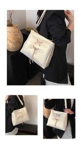 Detail of balletcore cream tote bag with light pink ribbon and metal buckle accents