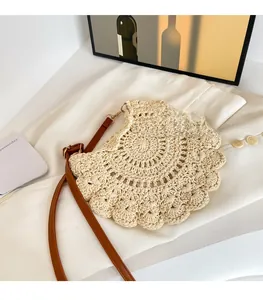 Detail of crochet weaving patterns and brown leather strap on a beige crossbody bag