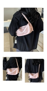 Detail view of pink shoulder bag with black and white gradient fringe tassel and subtle texture
