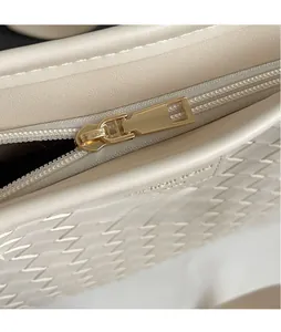 Detail of premium golden zipper slider on a cream woven texture large tote bag