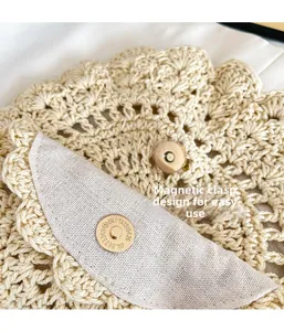 Detail of hand-woven lace pattern and golden magnetic closure on the beige crochet bag
