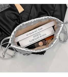 Top view showing large interior capacity of silver drawstring bucket bag with chain