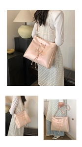 Detailed view of ballet-style pink shoulder bag with bow and cross-strap leather texture