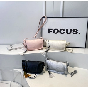 Detail of four chic faux leather shoulder bags in pink, cream, black, and silver with tassels