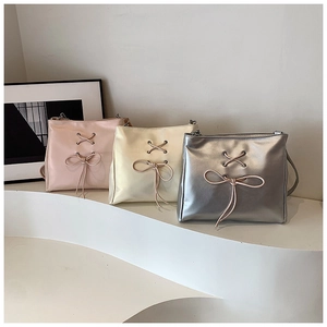 Detailed view of three ballet-style shoulder bags in pink, cream, and silver colors