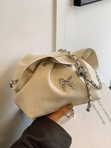 Chic cream cloud bag with silver butterfly charm and chain strap for elegant style