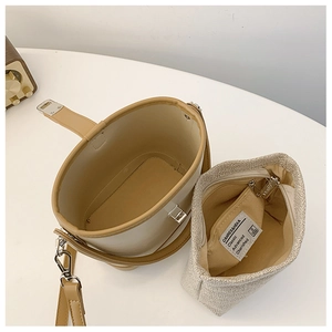 Detailed top view of beige bucket bag with removable linen inner pouch and metal clasp
