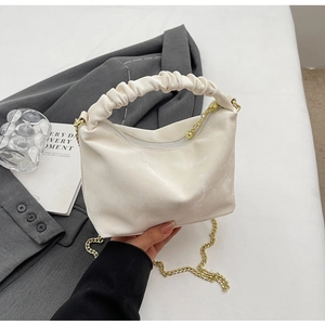 Detail of white pleated cloud bag with scrunchie handle and gold chain strap