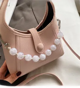 Detail of pink PU leather bag with lychee texture and marble beaded chain handle