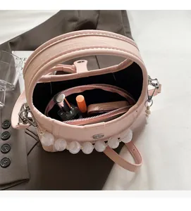 Detail view of pink beaded bucket bag interior with matching zipper pouch and inner space