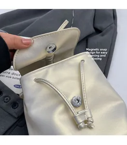 Détail du sac à dos blanc perle avec boucle magnétique et cordon en cuir
