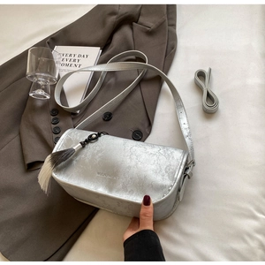 Detail of silver rectangle shoulder bag with bamboo leaf pattern and stylish tassel charm