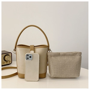 Detail of compact contrast bucket bag showing texture and smartphone for size reference