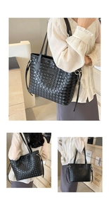 Detail of black woven tote bag showing the Intrecciato texture and brand logo plate