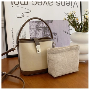 Detail view of contrast color bucket bag with metal lock and woven inner pouch