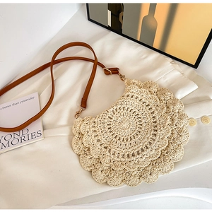 Detail of hollow woven shoulder bag with floral lace edges and brown leather strap