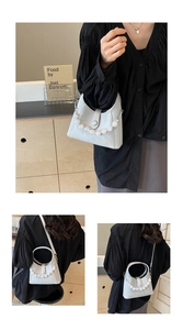 Detail of beaded handle on half-moon leather bag with adjustable long shoulder strap