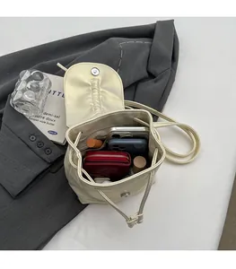Détail de la capacité intérieure du mini sac à dos beige avec téléphone et portefeuille