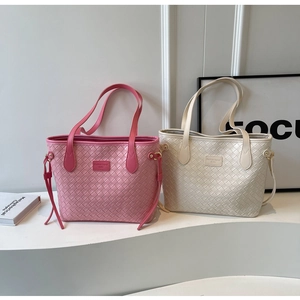 Detail of woven leather tote bags in pink and ivory with elegant side drawstring accents