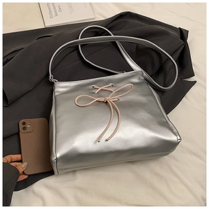 Macro shot of silver balletcore tote bag featuring soft pink bow and metallic finish