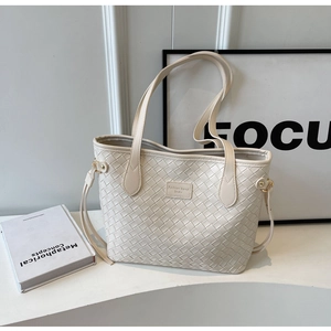 Detail of minimalist woven tote bag with Fashion trend leather patch and gold hardware