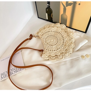 Close-up of beige crochet woven bag showing hollow circular texture and brown leather strap