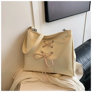 Close-up of cream PU leather bag featuring elegant ballet-style lace-up and bow details