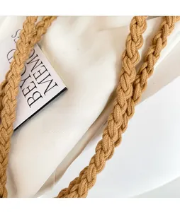 Detailed close-up of thick khaki woven cotton rope shoulder straps on a summer bag