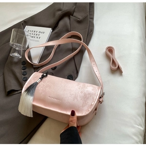 Detail of pink pearlescent bag with bamboo embossing and gradient tassel charm