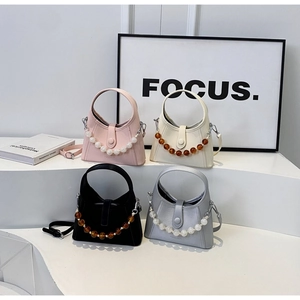 Four elegant crossbody bags in pink, white, black and silver with stylish beaded chains