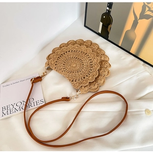 Detail of hand-woven crochet shoulder bag with scalloped edges and slim leather strap