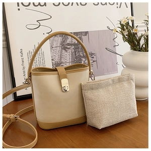 Detail of contrast color bucket bag with silver metal buckle and linen inner pouch