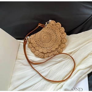 Detailed macro view of khaki crochet lace bag with wavy edges and brown leather strap