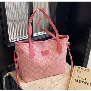 Detail of pink woven tote bag showing luxury leather texture and braided pattern