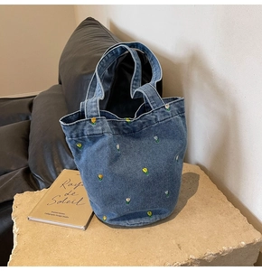Detail der Tulpenstickerei auf einer dunkelblauen Denim-Beuteltasche mit Henkeln