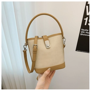 Close-up of contrast color bucket bag featuring silver metal lock and leather strap