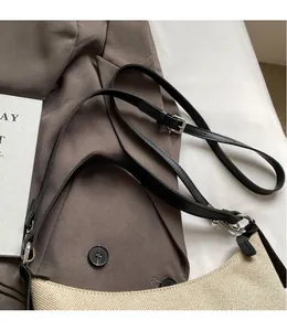 Détail de la bandoulière en cuir réglable et de la texture tissée du sac beige