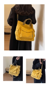 Detailed macro view of yellow canvas tote bag with large front pockets and brown straps