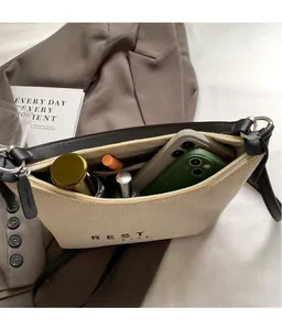 Détail de l'intérieur spacieux du sac en toile et cuir avec petits accessoires